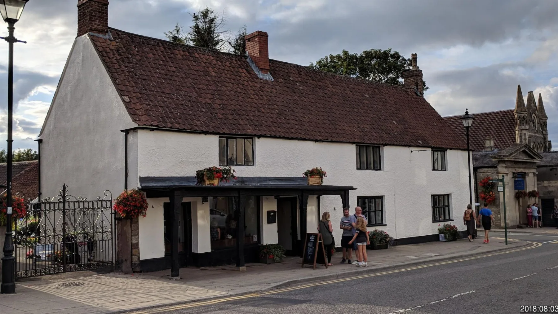 The historic Butcher’s Hook frontage with hanging flowers and guests on Thornbury High Street