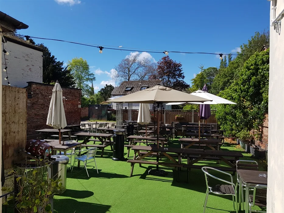 The Strand’s sunny beer garden with parasols, greenery and festoon lights
