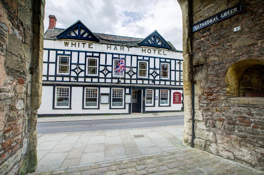 The White Hart seen through the stone arch from Cathedral Green in Wells